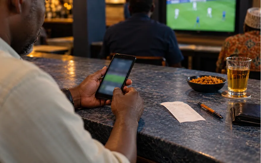 Hands close a phone beside a betting receipt to illustrate taking a break